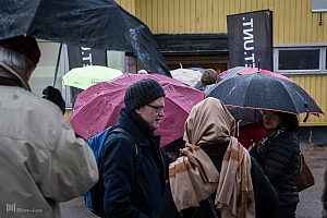 En tapper skara väntar i regnet