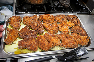 Färdigstekta kotletter på väg in i ugnen.